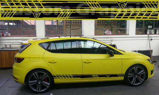 A yellow Seat Leon hatchback with a set of premium vinyl stickers featuring black and white stripes applied on the side.