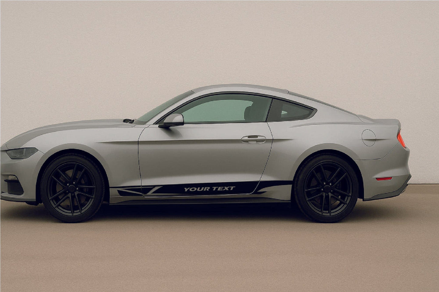 Side view of a light gray car with black wheels on a beige floor.