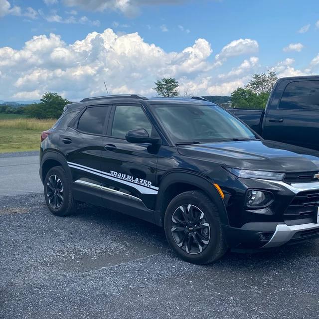 Black SUV with 'Traveler' branding on a road with a scenic background