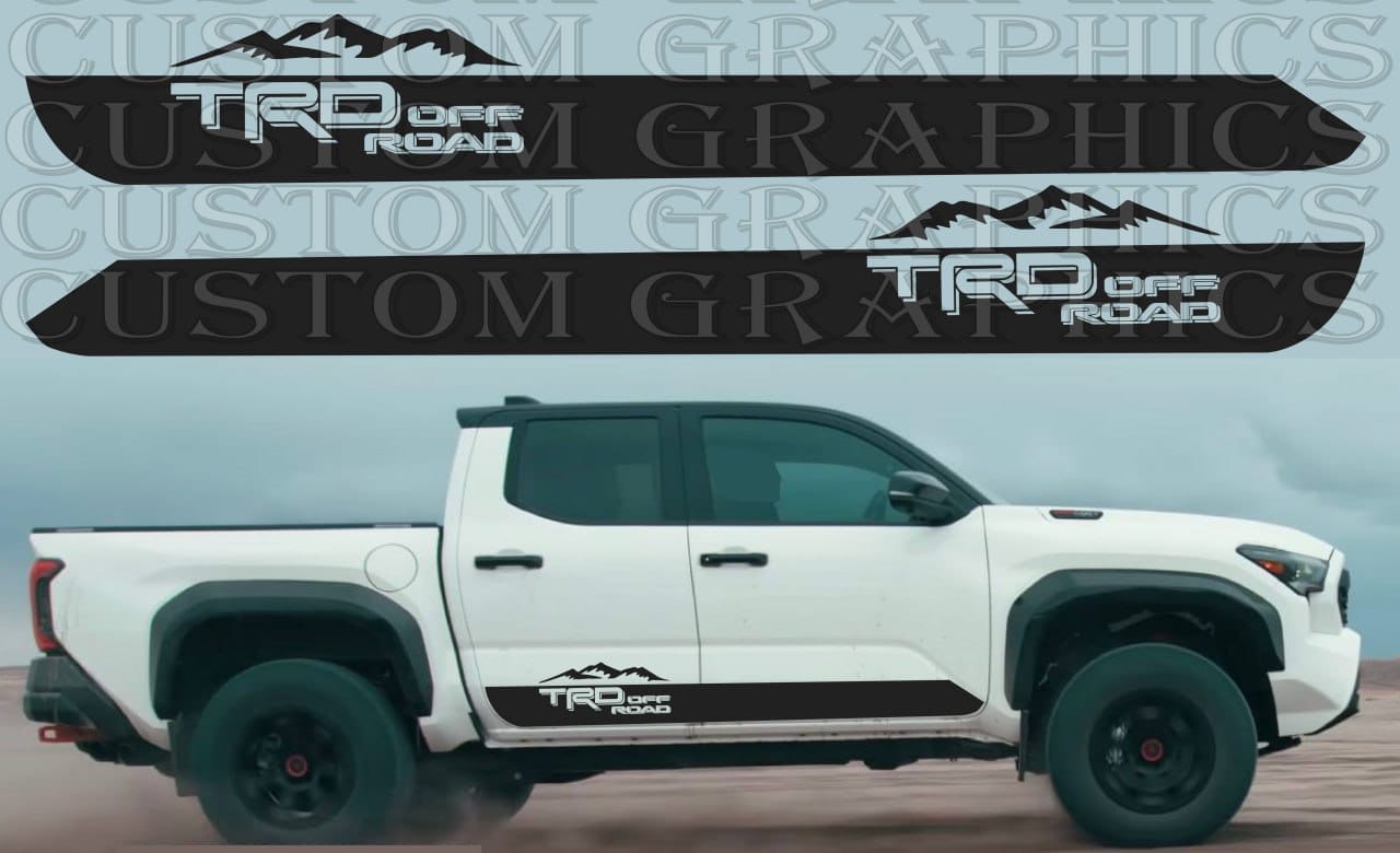 A white Toyota Tacoma pickup truck with a set of custom decals on the side, featuring a mountain design.