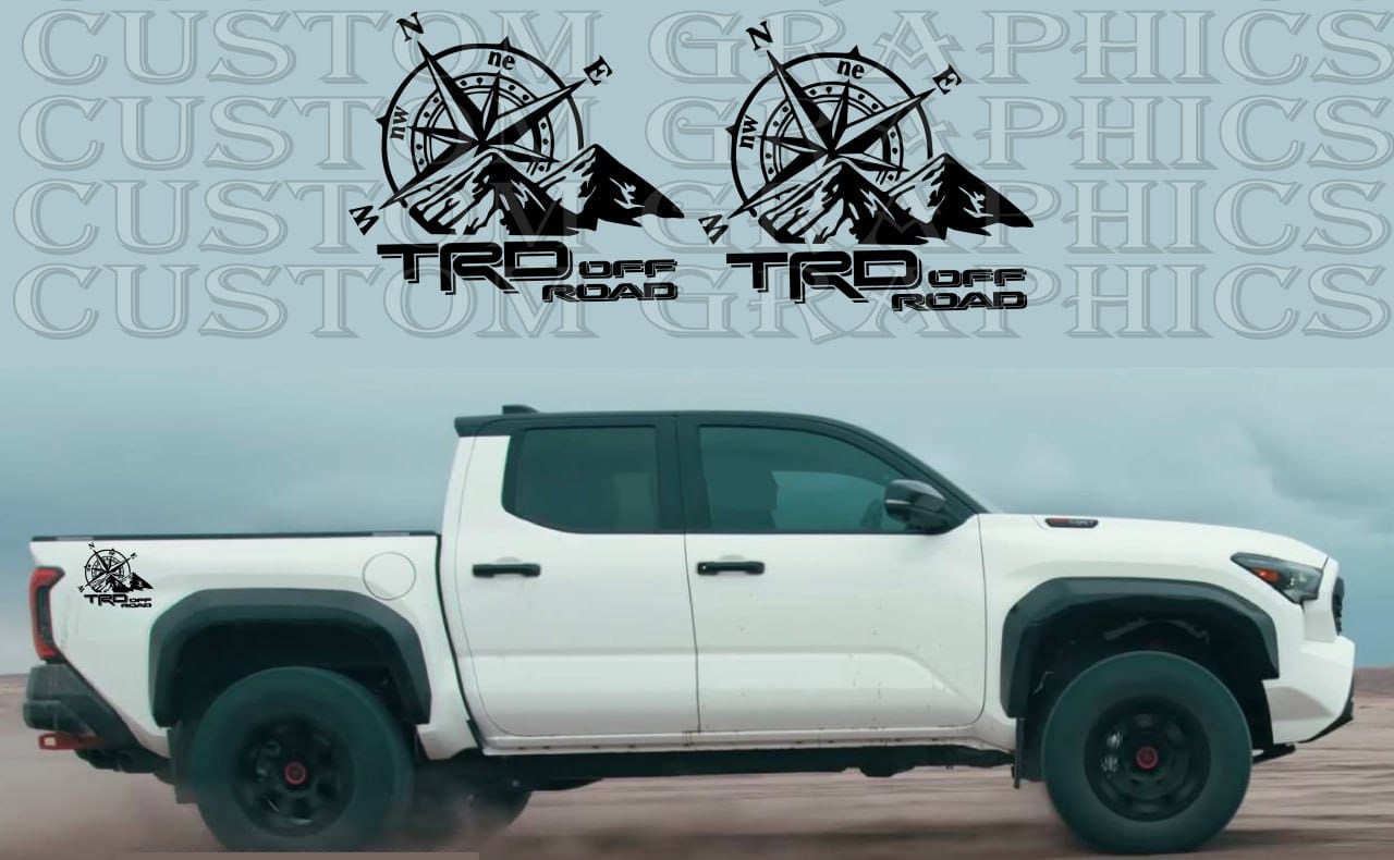 A white Toyota Tacoma pickup truck with a set of custom decals on the side, featuring a compass design.