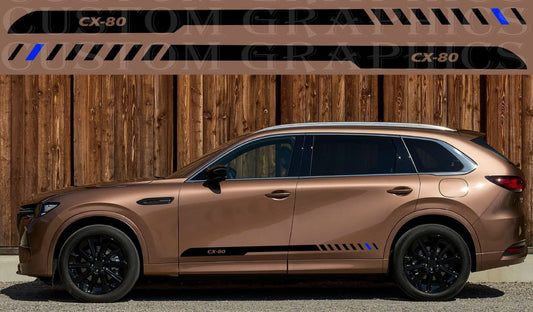 Bronze-colored SUV parked in front of a wooden wall with 'OM Graphics' branding.