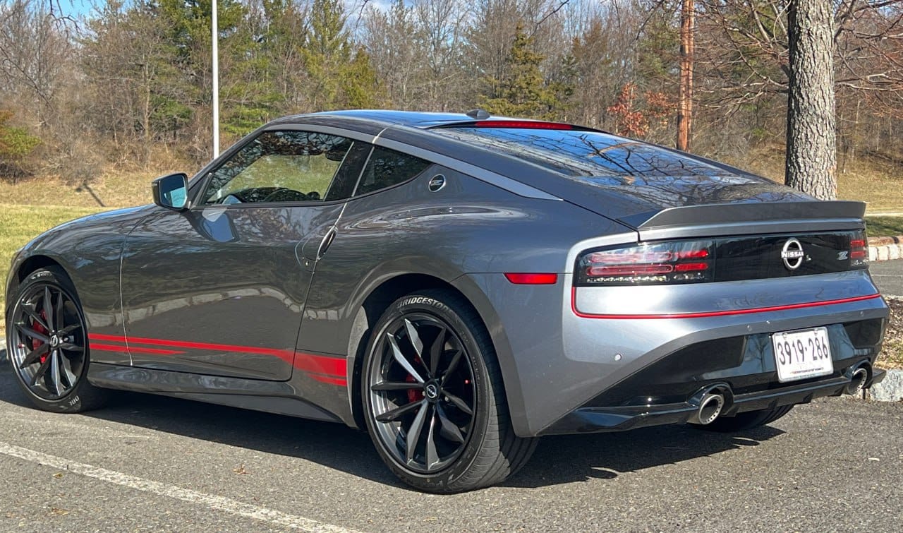 A Nissan Z car with a set of vinyl stripes decals applied on the side, parked on a road.